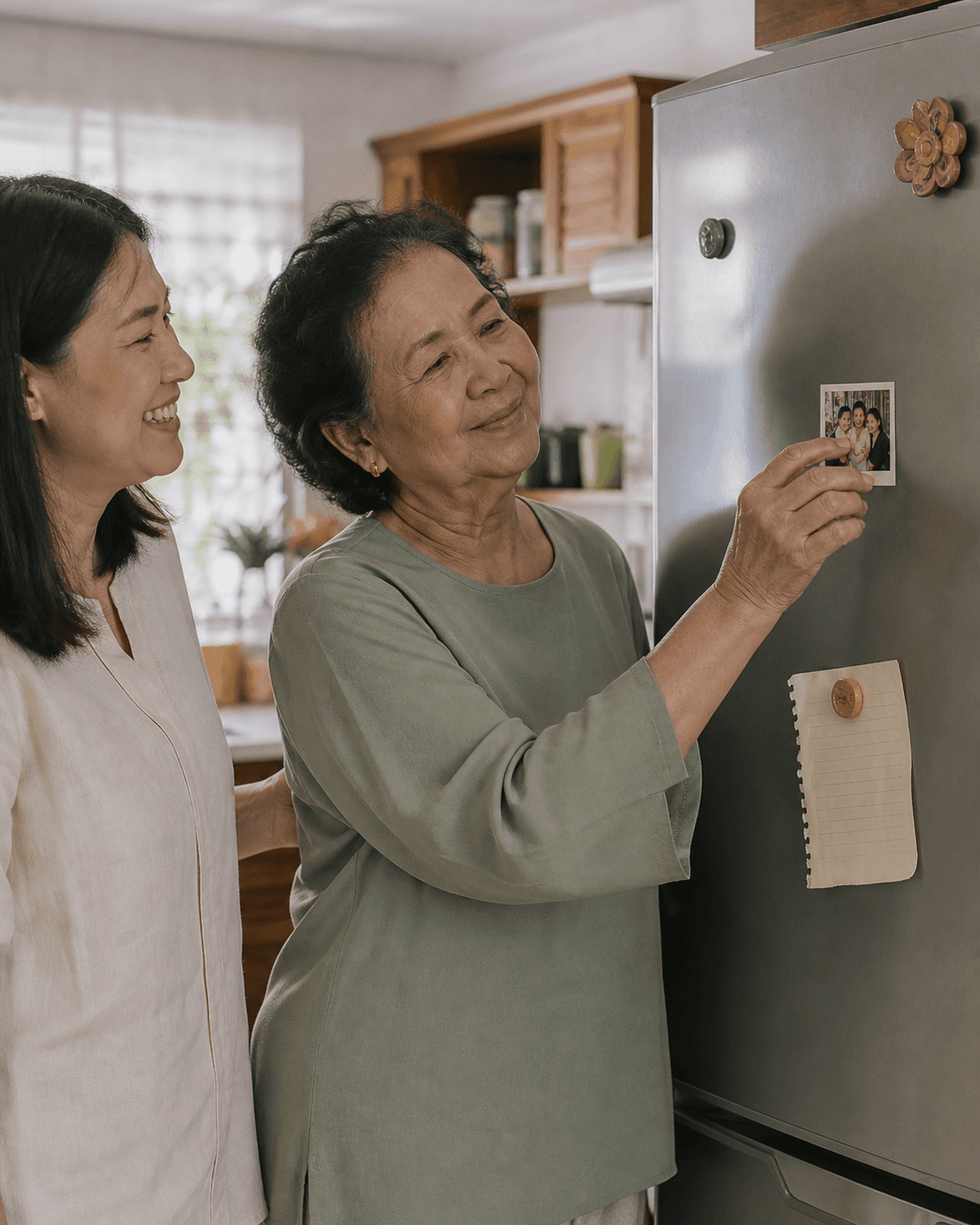 A Malaysian grandmother and daughter placing a family photo magnet on their fridge