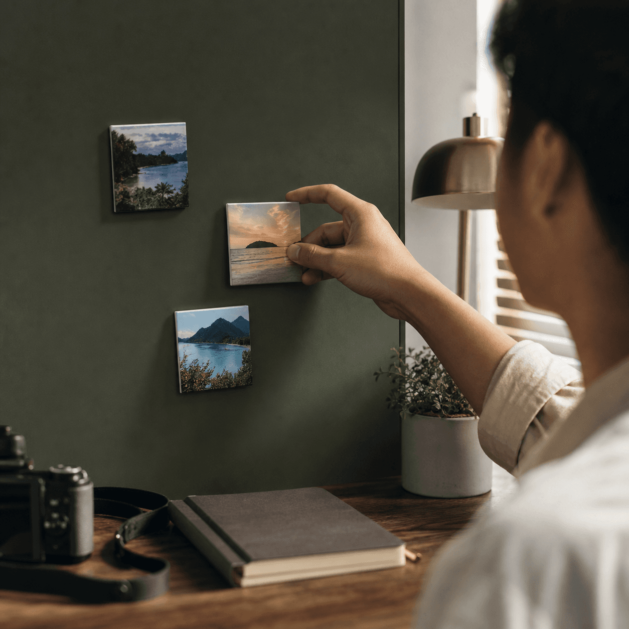 A traveller placing a favourite island photograph on a magnetic workspace board